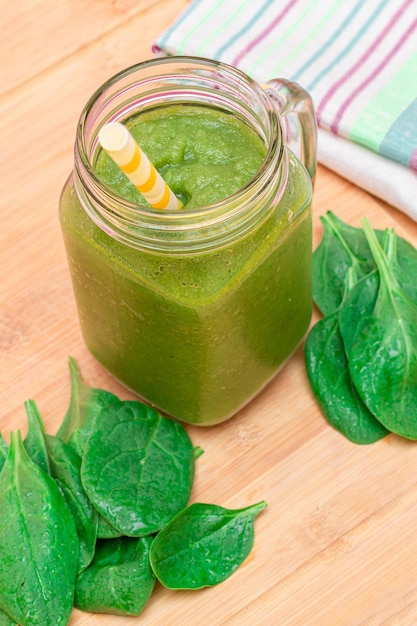 Fresh green smoothie of apple celery and spinach in glass smoothie jar