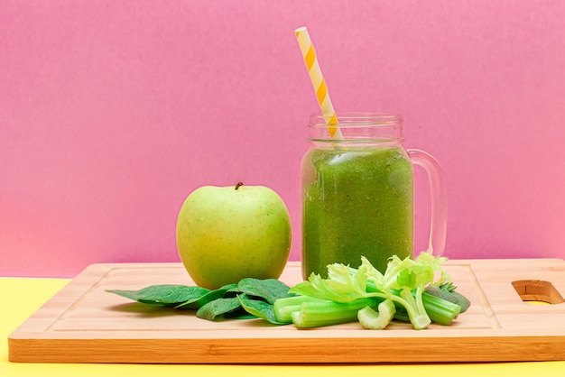 Fresh green smoothie of apple celery and spinach in glass smoothie jar