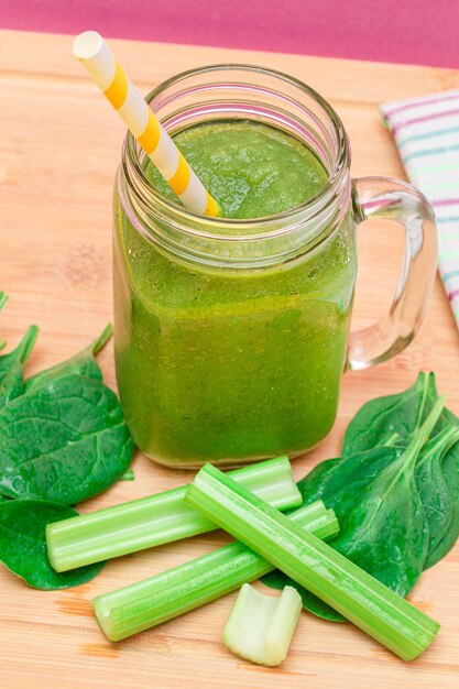 Fresh green smoothie of apple celery and spinach in glass smoothie jar