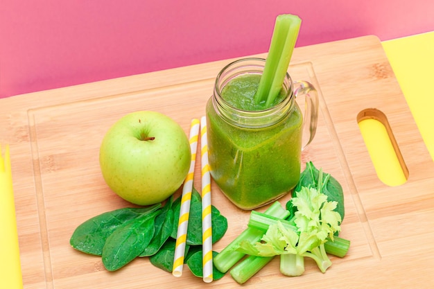 Fresh green smoothie of apple celery and spinach in glass smoothie jar