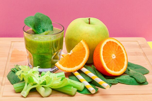 Fresh green smoothie of apple celery spinach and orange in glass beaker