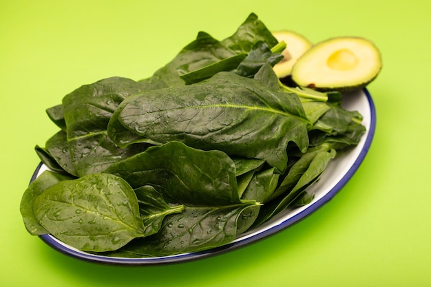 Spinaci verdi freschi sul piatto su verde