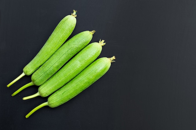 Foto zucca o orza verde fresca della spugna sulla superficie scura