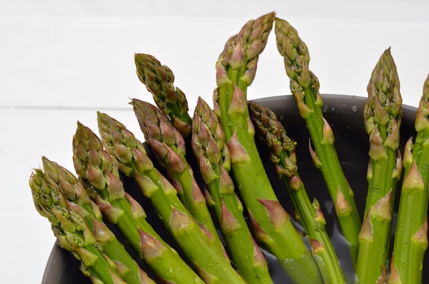 Fresh green sprout of asparagus in a bowl of water