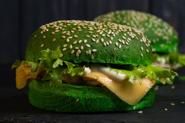 Fresh green tasty burger on black background