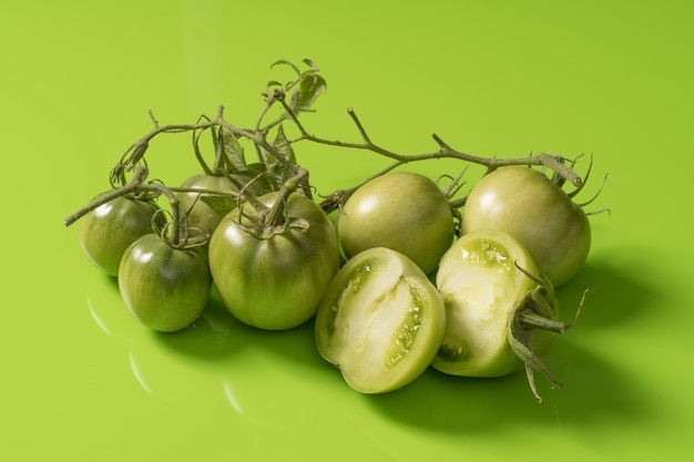 Fresh green tomatoes on a solid background