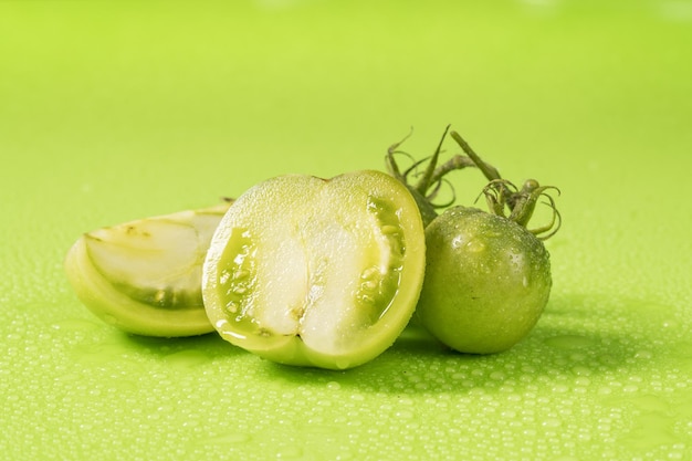 Fresh green tomatoes on a solid background