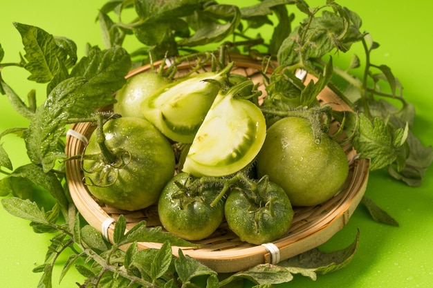 Fresh green tomatoes on a solid background