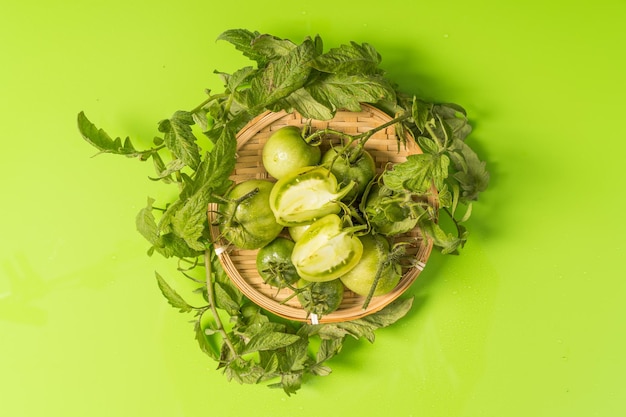 Fresh green tomatoes on a solid background