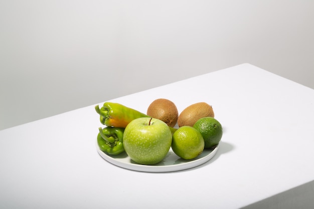 Fresh green vegetables and fruits on white table. Alkaline diet concept