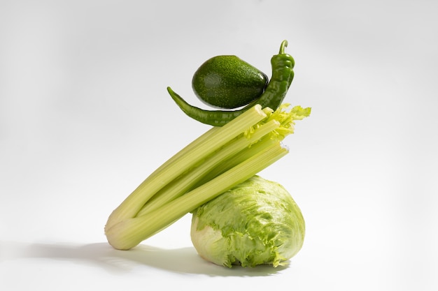 Fresh green vegetables on gray background. Food balance of pepper,celery,salad and avocado