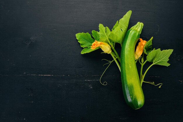 Fresh green zucchini on a black wooden table Top view Copy space