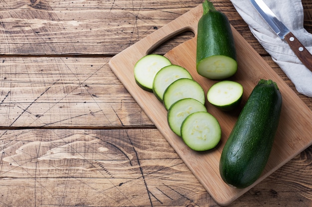 Fresh green zucchini cut into slices on a cutting Board.