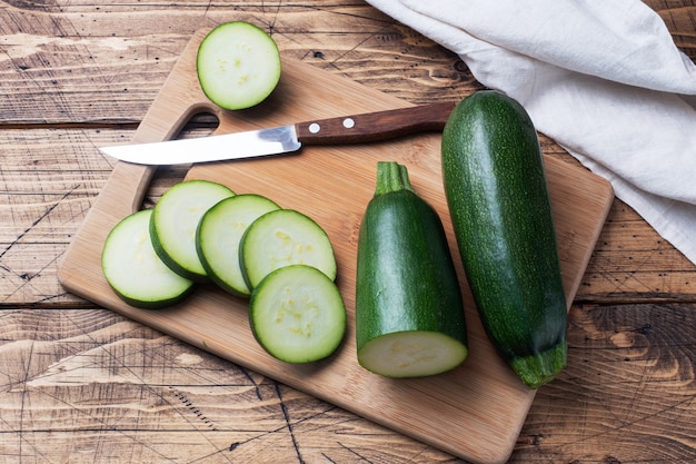 Fresh green zucchini cut into slices on a cutting Board.