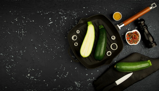 Fresh green zucchini on a dark table. The view from the top. Copy space.