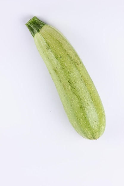 白い背景に分離された新鮮な緑のズッキーニ 緑の野菜のクローズ アップ 健康食品のコンセプト