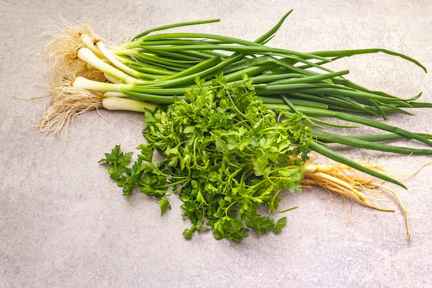 Fresh greens on a stone table, top view