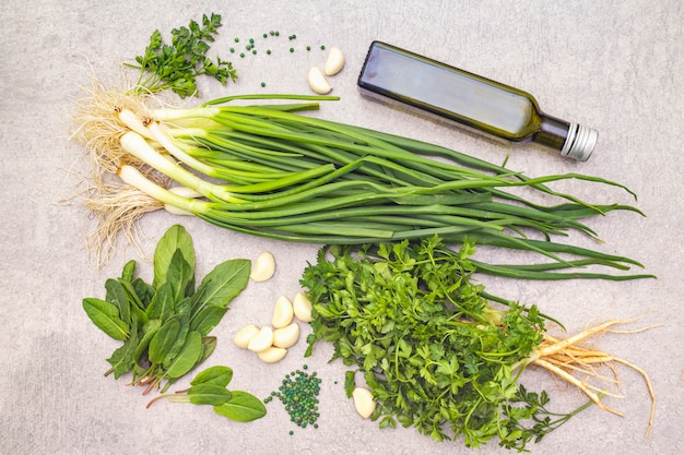 Fresh greens on a stone table, top view