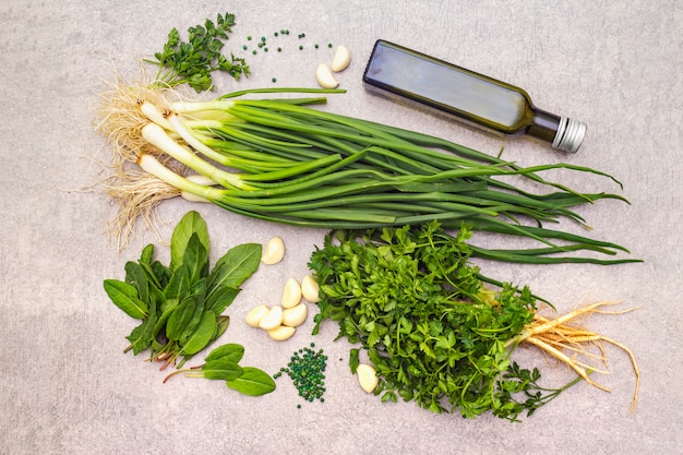 Fresh greens on a stone table, top view