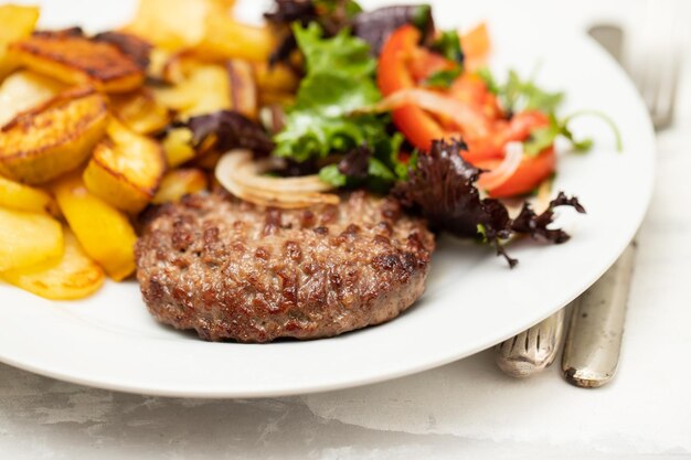 Fresh grilled hamburgers with potato and salad on plate