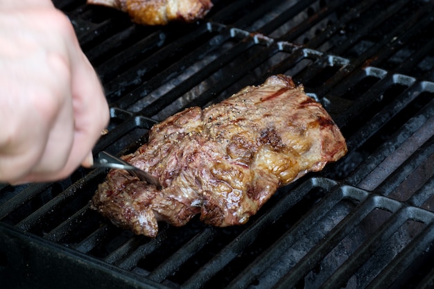 Fresh grilled meat. Grilling steaks on flaming grill. High quality photo