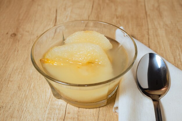 Fresh half Pears Served with sweet syrup. Wooden table background.