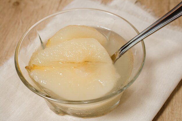 Photo fresh half pears served with sweet syrup. wooden table background.