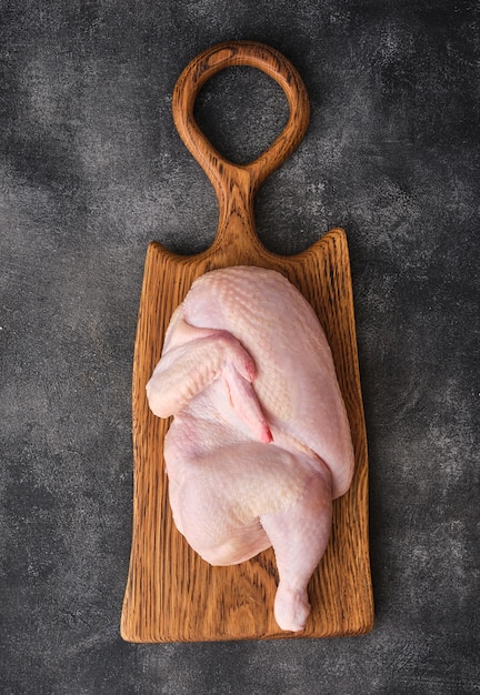 Fresh half of raw chicken on a wooden board