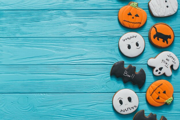 Fresh halloween gingerbread cookies on blue wooden table.