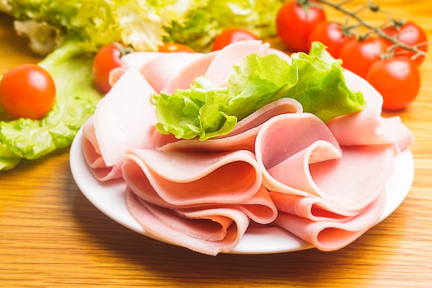 Fresh ham slices with lattuce and cherry tomato on the plate