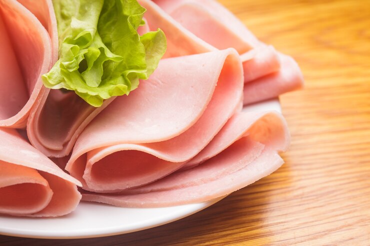Photo 접시에 양상추와 체리 토마토를 곁들인 신선한 햄 조각