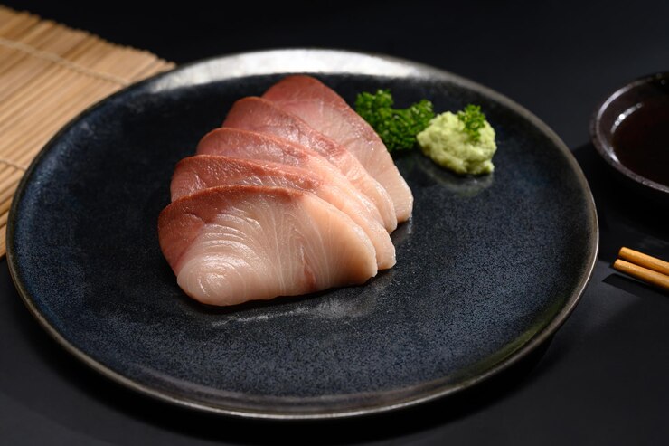 パーセリー葉の黒いプレートに新鮮なハマチサシミ 日本料理スタイル