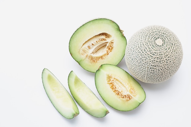 Fresh Hami cantaloupe melon with slices isolated on white background.