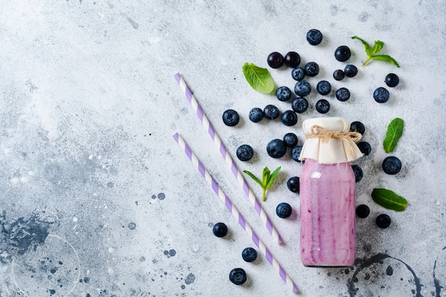 사진 신선한 건강 한 블루 베리 스무디 딸기와 밝은 흰색 콘크리트 표면에 유리 항아리에 민트. 제로 폐기물 개념 .top 뷰