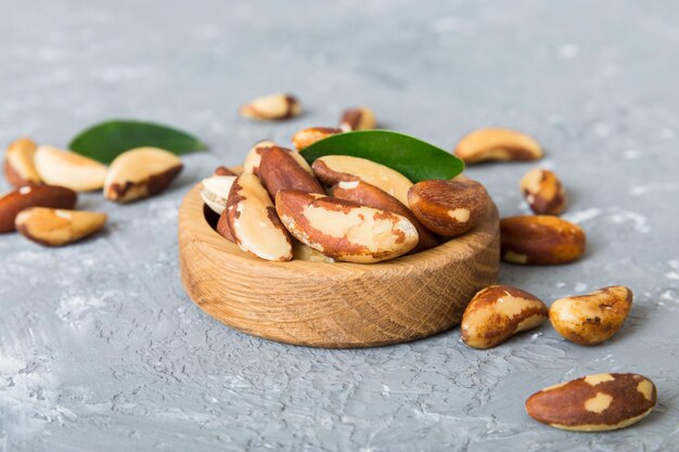 Fresh healthy Brazil nuts in bowl on colored table background Top view Healthy eating bertholletia concept Super foods