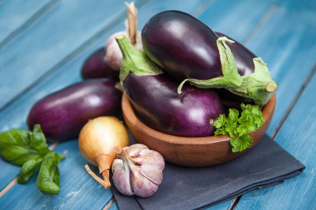 Fresh healthy eggplants on dark wooden background