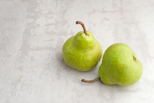 Fresh and healthy green pear fruits on grey background Close up selected focus