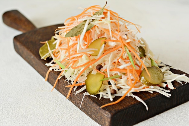 Fresh healthy salad  cabbage carrotpickle Coleslaw on a wooden board on a light background