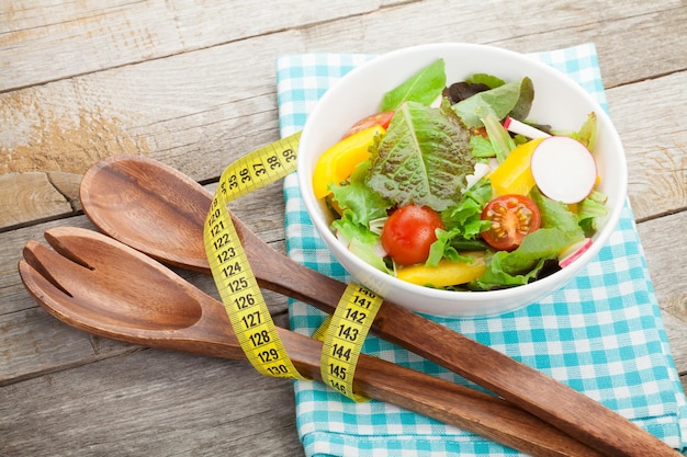 Fresh healthy salad and kitchen utensils