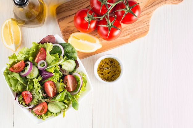 Insalata fresca e sana con deliziosi spinaci, formaggio feta, cipolla rossa, cetriolo e pomodorini