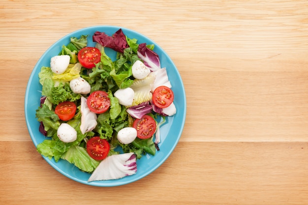 Fresh healthy salad on wooden table with copy space