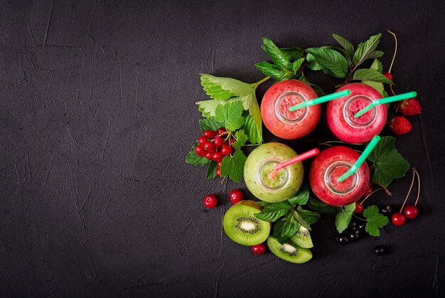 Frullati freschi sani da bacche diverse su uno sfondo scuro. menù dietetico