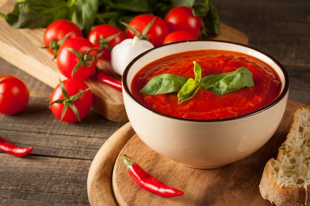 Свежий, полезный томатный суп с базиликом, перцем, чесноком, помидорами и хлебом. Испанский суп гаспачо.