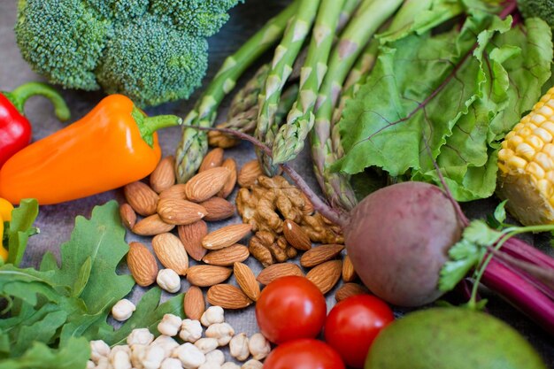 Fresh healthy vegetarian food background Vegetarian food concept Vegetables nuts beans and chickpeas on a black background