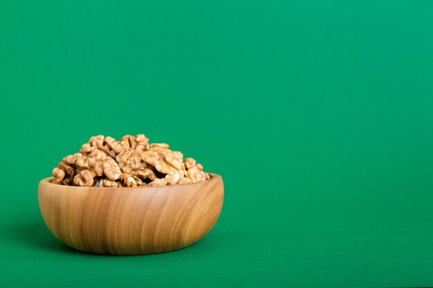 Fresh healthy walnuts in bowl on colored table background Top view Healthy eating bertholletia concept Super foods