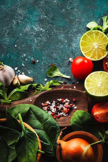 Fresh helthy food cooking vegetable ingredients on dark background with rustic wooden board Diet or vegetarian food concept Top view copy space