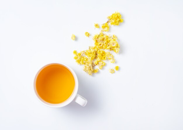 Fresh herbal tea with yellow flowers on a white background