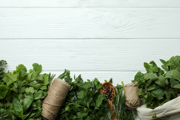 Fresh herbs on white wooden background, space for text