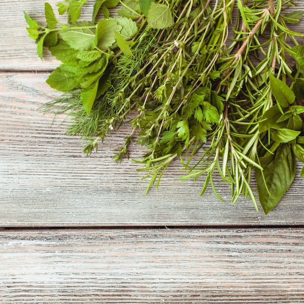 Photo fresh herbs on the wooden background with copy text