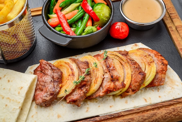 Fresh, home-cooked on the grill fire meat beef shish kebab with vegetables and spices